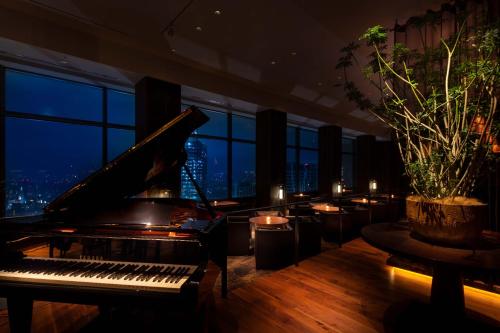 a piano in a room with a view of the city at Cerulean Tower Tokyu Hotel, A Pan Pacific Partner Hotel in Tokyo