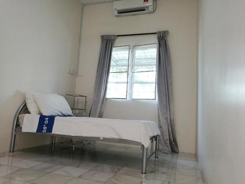 a hospital bed in a room with a window at Guesthouse Dragon Place in Taiping