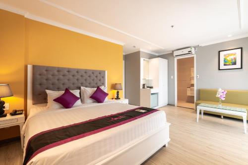 a bedroom with a large bed with purple pillows at Avanti Boutique Hotel in Ho Chi Minh City