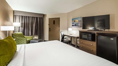 Habitación de hotel con cama y TV de pantalla plana. en Best Western Center Inn en Virginia Beach