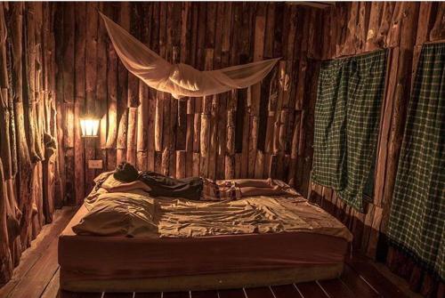 a bedroom with a bed in a wooden wall at Pano Resort in Ko Mak