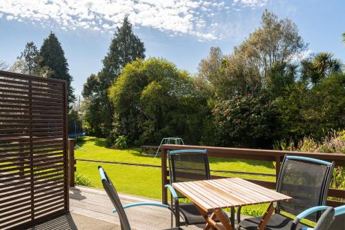 a wooden table and chairs on a deck at Golden Bay Motel in Takaka