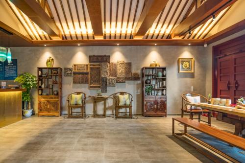 a room with chairs and a table and shelves at Guipu Beihai Courtyard Hotel in Beijing