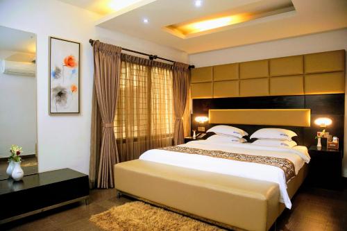 Un pat sau paturi într-o cameră la D'more Dhaka Hotel & Resort