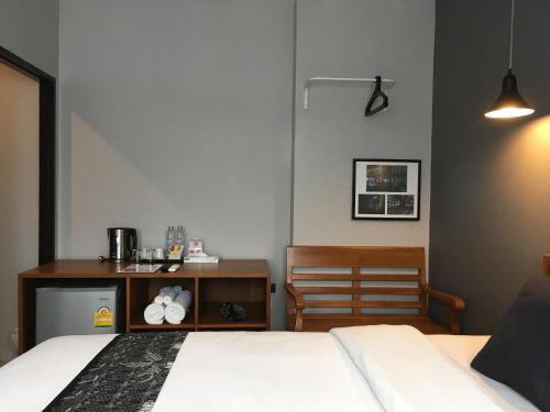 a bedroom with a bed and a desk and a chair at The Besavana Phuket - SHA Extra Plus in Phuket Town