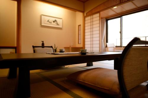 a dining room with a table and a window at Iizaka Onsen Surikamitei Ohtori in Fukushima