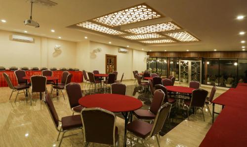 a banquet hall with red tables and chairs at Treebo Blessing Bells in Dehradun