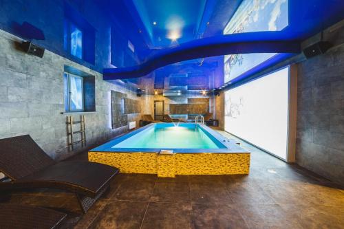 a swimming pool in a room with a blue ceiling at Aquamarine hotel&spa in Kursk