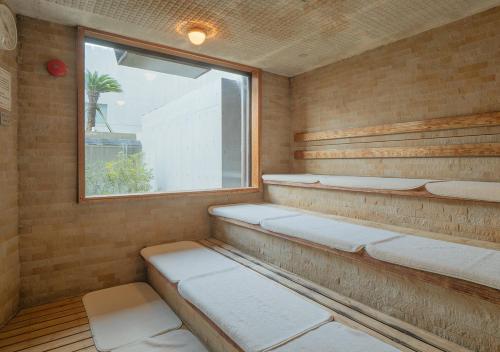 a sauna with a window and white seats in it at THE HOTEL YAKUSHIMA ocean & forest in Yakushima