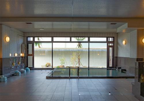 a large swimming pool in a room with a large window at THE HOTEL YAKUSHIMA ocean & forest in Yakushima