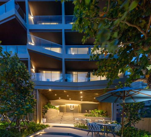 an apartment building with a patio and an umbrella at U Jomtien Pattaya in Jomtien Beach