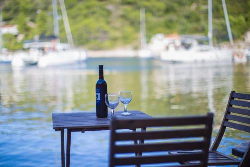 uma garrafa de vinho sentada numa mesa com dois copos em Holiday House Macić em Vis