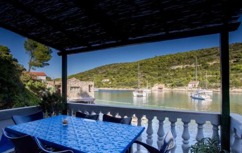 a table on a balcony with a view of the water at Holiday House Macić in Vis