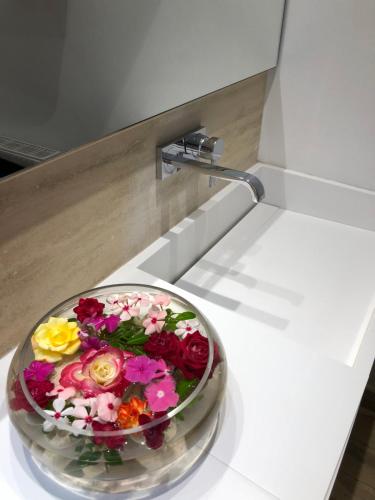 a bouquet of flowers in a bowl on a counter at Droushia Heights Hotel in Droushia