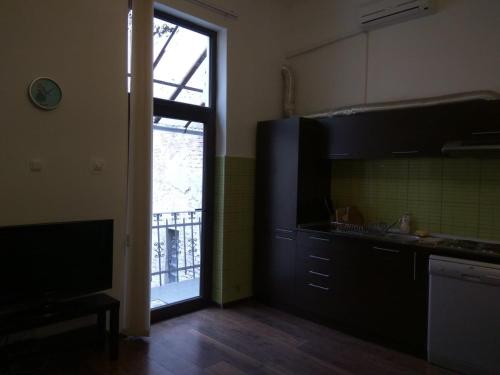 a kitchen with a television and a door to a balcony at Laura Studio - Central in Oradea