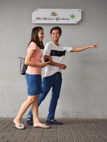 a man and a woman standing next to a wall at POP! Hotel Kelapa Gading in Jakarta