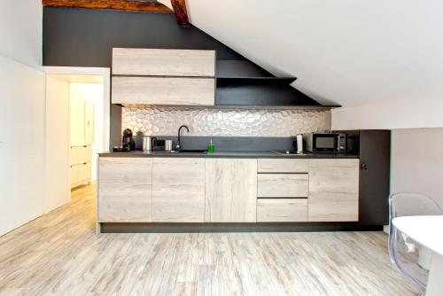 a kitchen with wooden cabinets and a sink at Lofty apartments in Sarajevo