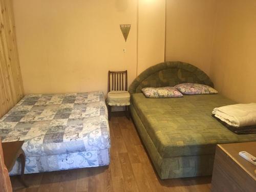a room with two beds and a chair in it at Dom v Arkadii in Odesa