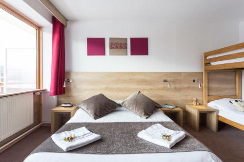 een slaapkamer met 2 bedden en een groot raam bij Hôtel Club mmv Le Panorama *** in Les Deux Alpes