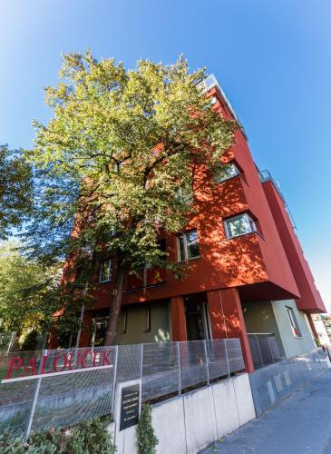 a red building with a tree in front of it at Penzion Palouček in Prague