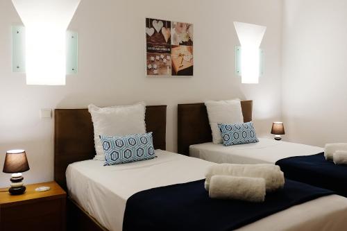 two beds with blue and white pillows in a room at LOTUS VILLA, Albufeira in Albufeira