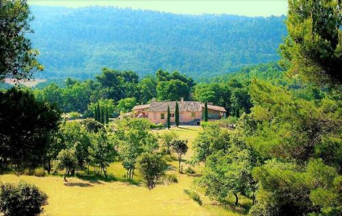 an old house in the middle of a field with trees at Le Mas Sérénité in Ansouis