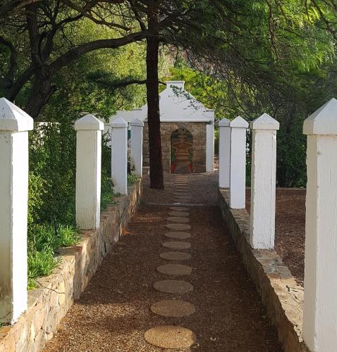 a path in a cemetery with white fences and a tree at Montagu Little Sanctuary - Hot Spring Access at Special Rate in Montagu
