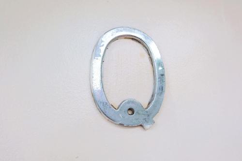 a metal letter q on a white wall at RQS Hostel in Tacloban