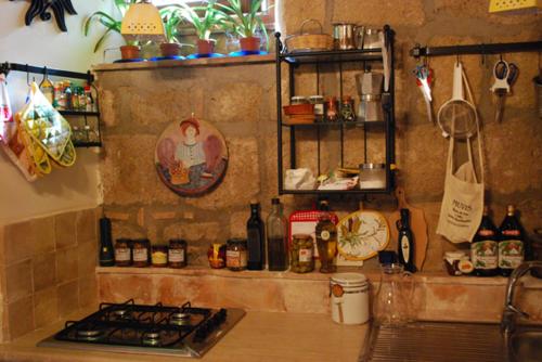een keuken met een fornuis en enkele flessen en planken bij Living into History in Farnese