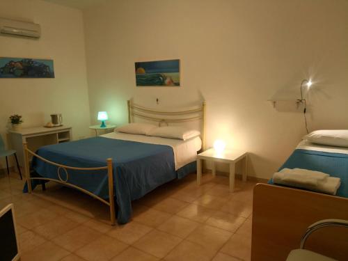 1 dormitorio con 1 cama y 2 mesas con lámparas en B&B Vento di Terra, en Gaeta