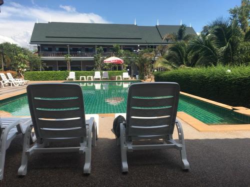 two chairs sitting in front of a swimming pool at Oscar Villa Aonang Krabi in Ao Nang Beach