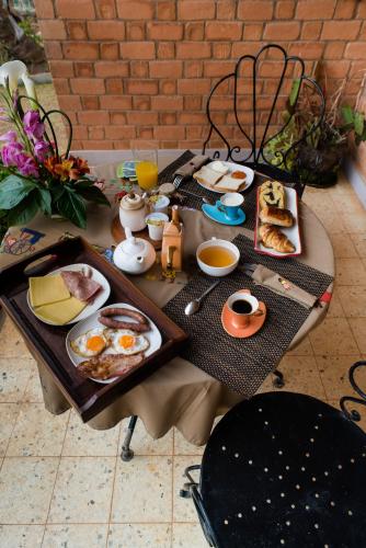 a table with breakfast foods and drinks on it at Somptua Garden in Ivato