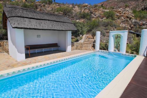 a swimming pool with a bench next to a house at Montagu Little Sanctuary - Hot Spring Access at reduced price in Montagu