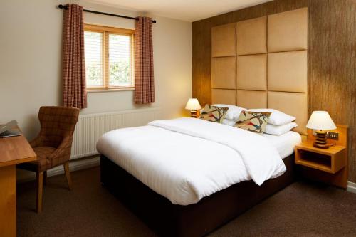 a bedroom with a bed and a desk and a chair at The Motel, Ribby Hall Village in Wrea Green