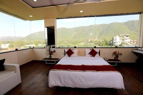 a bedroom with a large bed and a large window at Rock Star Hotel in Pushkar