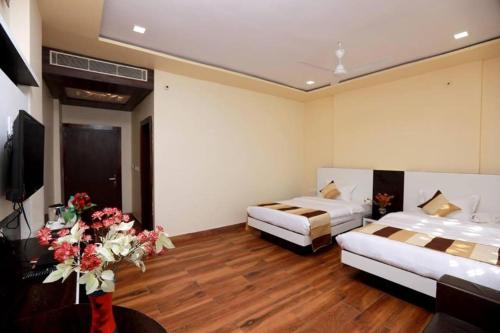 a hotel room with two beds and a television at Rock Star Hotel in Pushkar