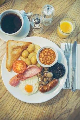 a plate of breakfast food with eggs sausage beans and toast at George Hotel, BW Signature Collection in Norwich
