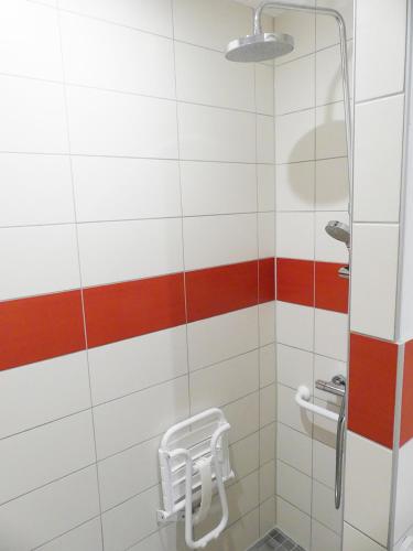 a bathroom with a shower with a stool in it at Hôtel Restaurant Aux Deux Roses in Neuf-Brisach