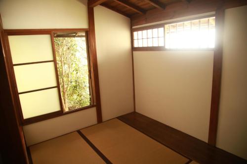 a room with a door and a window at Guest House Yukari in Tsuru 
