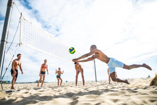 a group of people playing a game of volley ball on the beach at Wyndham Grand Phu Quoc in Phu Quoc