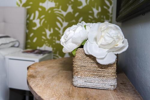 a basket with white flowers sitting on a table at Navona Studios in San Juan