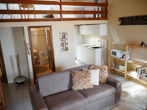 un soggiorno con divano e una cucina di Appartamenti Ca' nei Vicoli a Limone sul Garda