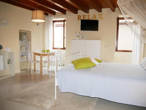una camera con un letto bianco e un tavolo di Appartamenti Ca' nei Vicoli a Limone sul Garda