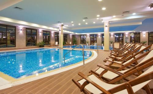 a pool in a hotel with chairs around it at Grand Hotel Velingrad in Velingrad
