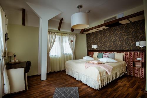 a bedroom with a large bed with a large window at Soare-n Maramureș in Budeşti