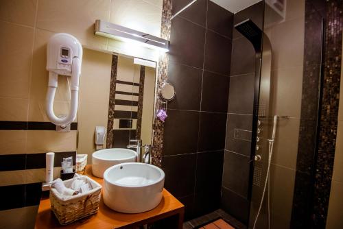 a bathroom with two sinks and a shower at Soare-n Maramureș in Budeşti