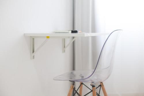 a glass table and a chair next to a wall at Sol Playa in Valencia