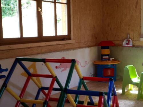 a room with colorful chairs and a table and windows at Chalet in Reinskopf with Fireplace & Balcony in Schönecken