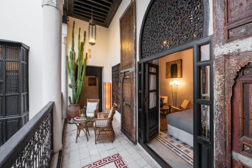 a room with a balcony with a bed and a table at 72 Hotel & Spa in Marrakech