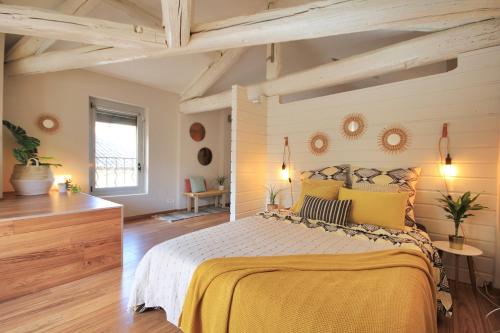 - une chambre dotée d'un grand lit avec des draps jaunes dans l'établissement Loft Isis - Appartement Avignon centre, à Avignon